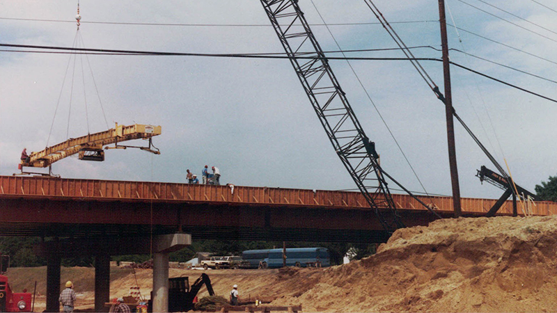 A shot of construction workers building the freeway using heavy duty equipment.